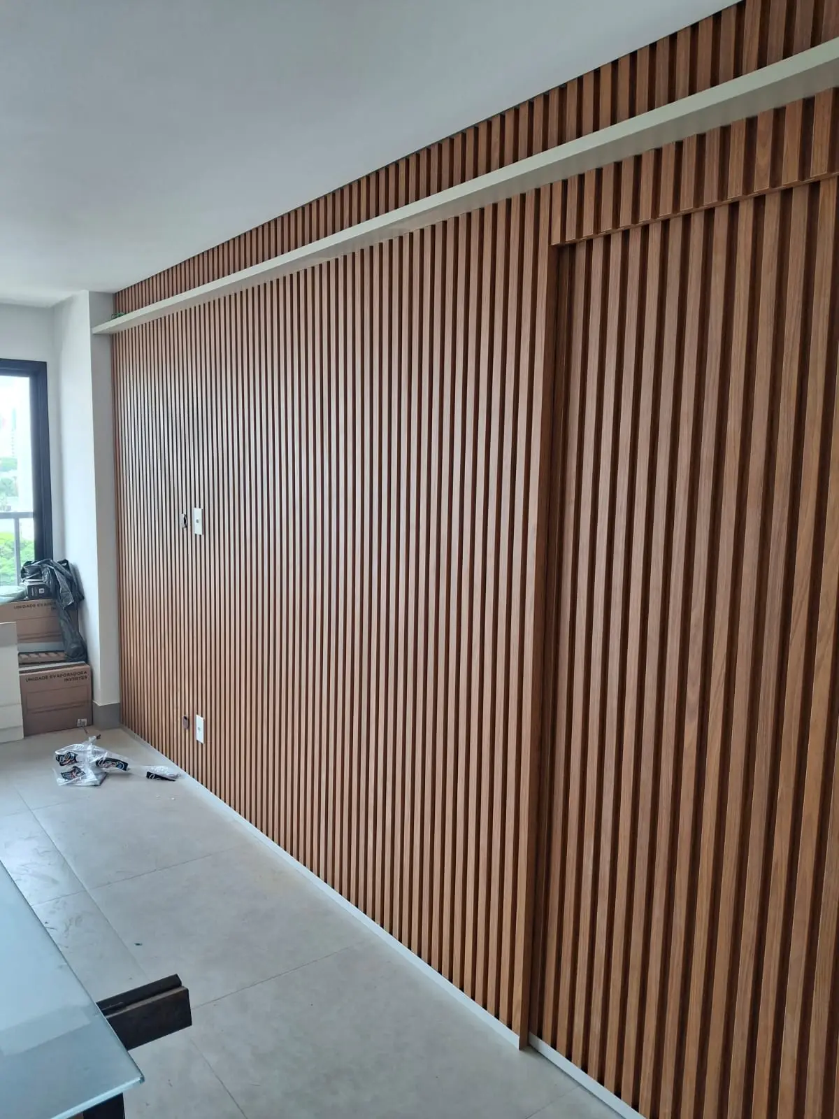 Sala de estar sofisticada com iluminação embutida nos painéis de MDF sob medida, criando uma atmosfera aconchegante e luxuosa